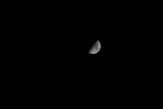 Half moon on the black sky at night for background and texture.