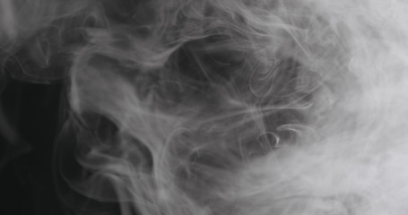 Slow motion closeup vapor floating in air on black background