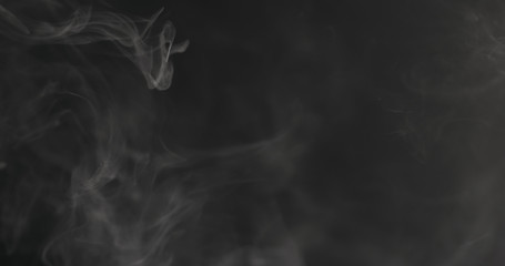 Slow motion closeup vapor floating in air on black background