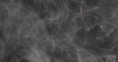 Slow motion closeup vapor floating in air on black background