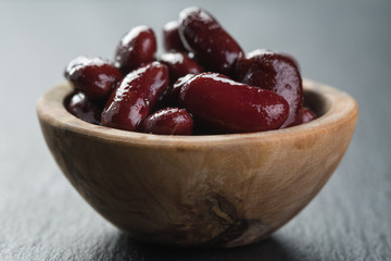 red canned beans in wood bowl on slate background