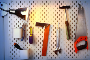 various construction tools hanging on the wall and a glow lamp