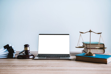 Workspace of lawyer with laptop blank white screen and law wooden gavel,legal book and brass scale...