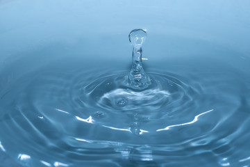 Wassertropfen im blauen Wasser mit Wellen als Hintergrund