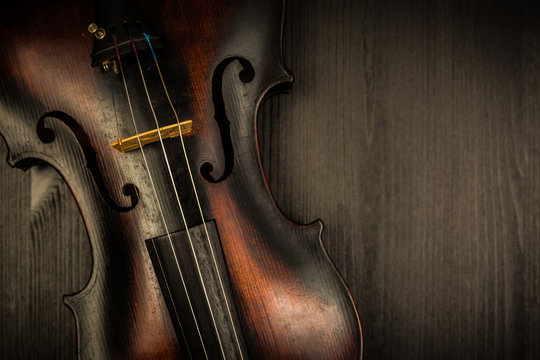 Detail of old violin in vintage style on wood background