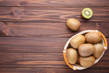 Kiwi in a basket on brown background