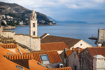 Tower of the Dominican Monastery in front of mountains in Dubrovnik with ocean view, Croatia