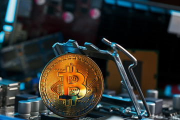 Golden Bitcoin Cryptocurrency on computer circuit board CPU. Macro shot.
