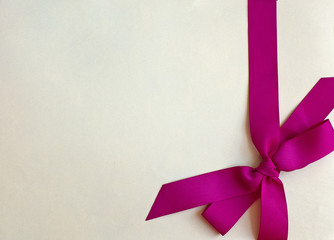 Decorative violet ribbon and bow on colored background. Greeting card.