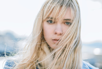 Portrait of young woman wearing blue coat.