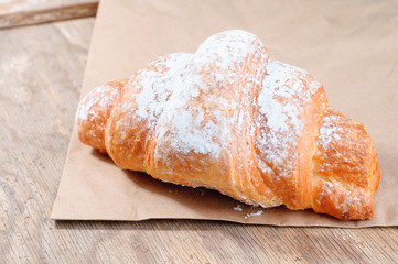 Baked Tasty croissants on old wooden background