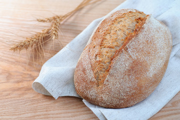 loaf of bread on wooden background, close-up view