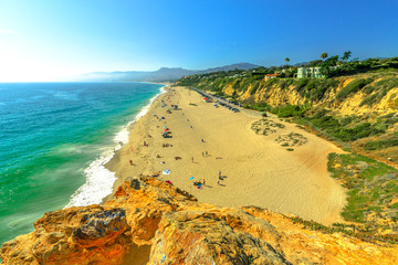 Aerial view of panoramic Point Dume State Beach from Point Dume promontory on Malibu coast, Pacific Ocean in CA, United States. California West Coast. Blue sky, summer season in sunny day. Copy space.