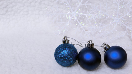 New year, christmas greeting card. Three blue christmas-tree ball on shiny snow background.