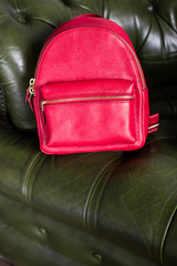 red leather backpacks on green leather sofa, womens leather backpacks, the front of the red rucksack (vertically)