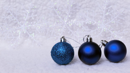 New year, christmas greeting card. Three blue christmas-tree ball on shiny snow background.