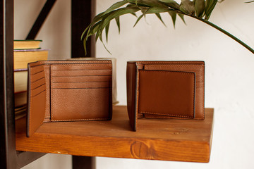 two mens leather wallet on a wooden shelf, leather wallet (horizontally, toned)