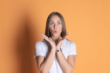 Obraz premium Young woman in casual clothing wondering and screaming isolated over yellow background.