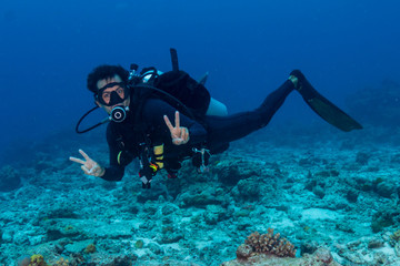 Naklejka na ściany i meble SCUBA diver underwater on a tropical coral reef