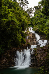 Fototapeta premium Long exposure of a beautiful waterfall running through tropical rainforest (Lampi, Thailand)