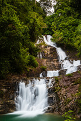 Fototapeta na wymiar Long exposure of a beautiful waterfall running through tropical rainforest (Lampi, Thailand)