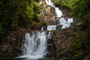 Fototapeta na wymiar Long exposure of a beautiful waterfall running through tropical rainforest (Lampi, Thailand)