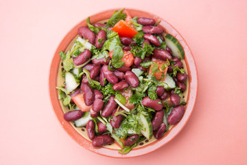 Cooked red beans plate on pink background, isolated. Healthy food.