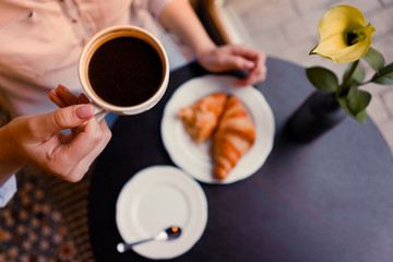 A girl whith coffe and croissants