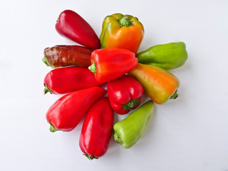 Many multicolored bell peppers isolated on white background