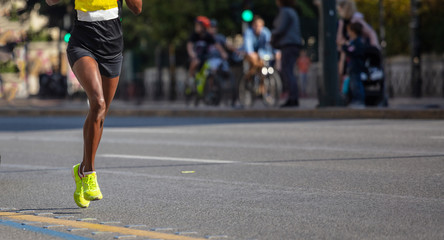 Running in the city roads. Young woman runner, front view, banner, blur background