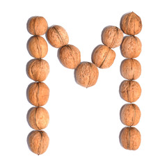 Letter M made with nuts to form a letter of the alphabet. Fruit letters on a white background.
