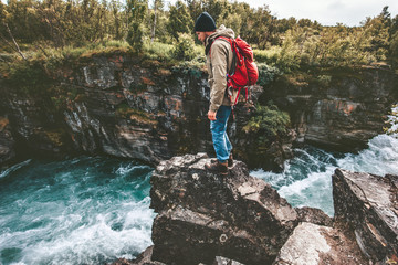 Hiker man standing on cliff alone active lifestyle adventure extreme vacations outdoor river canyon in Sweden
