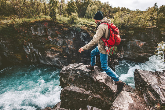 Active man trail running on rocks over river canyon hiking traveling lifestyle concept extreme journey vacations in Sweden wilderness - Powered by Adobe