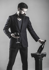 Sommelier man, degustator, winery, male winemaker. Bottle, red wine glass. Beard man, bearded, sommelier, tasting. Red wine in bottle, wineglass. Waiter, red wine in a glas. Black and white.
