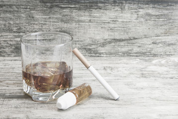 Not a full glass of alcoholic whiskey drink with an e-cigarette on a marble surface.Bad habits harmful to health 