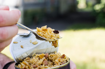 Testing cooked food. Fork in hand. To eat pilau.