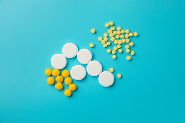 white and yellow medicines and pills on blue background