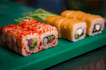Salmon sushi on green cutting board