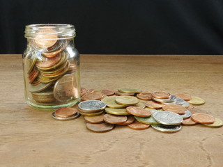 coins in jar on black background
