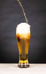 Pour beer in a glass with black background