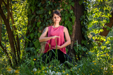 young woman meditates outdoors and channels her energy flow