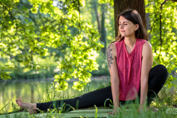 young female yogi practicing yoga in the park