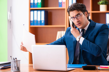 Young handsome businessman working in the office