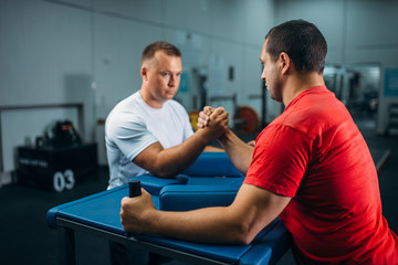 Two arm wrestlers at the table with pins, training