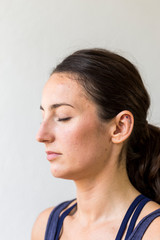 portrait of young woman meditating before yoga