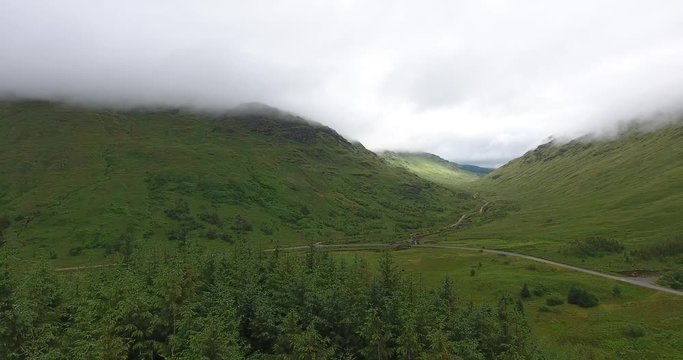 Small Road and River Drone Shot Between Hills in Scotland - Near Glencoe in the Highlands