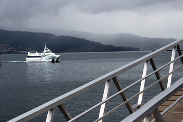  View of boat in the sea from metal bridge, mountain on the background  - 234059538