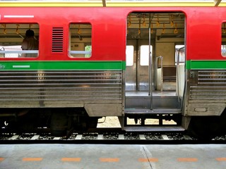 Side view of the old vintage multicolored passenger diesel train on railway in platform