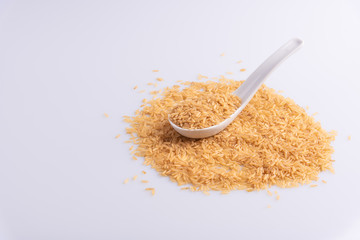 Raw Brown Rice on white background. Integral Wholegrain. Latin term Oryza sativa also known as Whole Chinese Rice seed