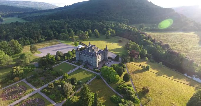 Scottish Hill Aerial Drone Pulling Back over Morning Countryside and Village - Inveraray Castle